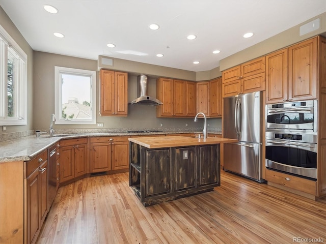 902 Anaconda Ct, Castle Rock, CO 80108 - kitchen with a center island with sink, wall chimney exhaust hood, stainless steel appliances, and a sink