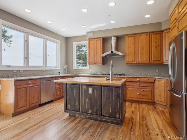902 Anaconda Ct, Castle Rock, CO 80108 - kitchen with recessed lighting, light wood-style floors, wall chimney range hood, a center island with sink, and appliances with stainless steel finishes