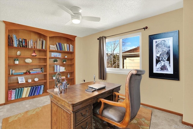 carpeted home office featuring ceiling fan and a textured ceiling