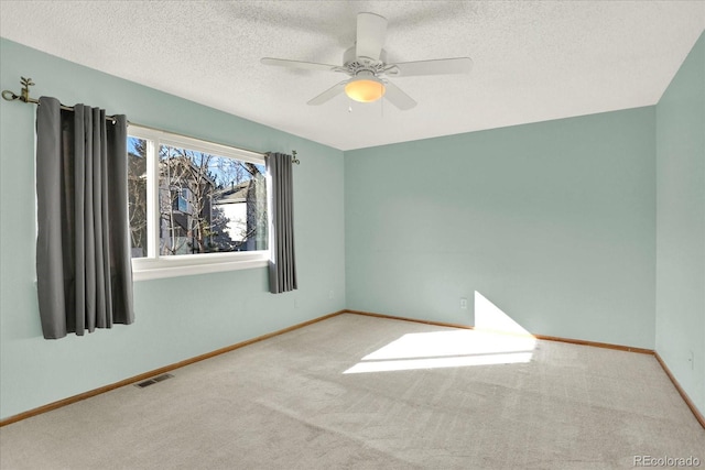 carpeted spare room with a textured ceiling and ceiling fan