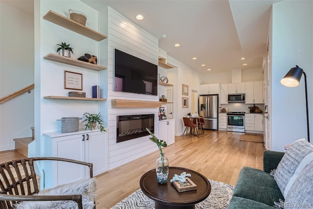 living room featuring a large fireplace and light hardwood / wood-style floors