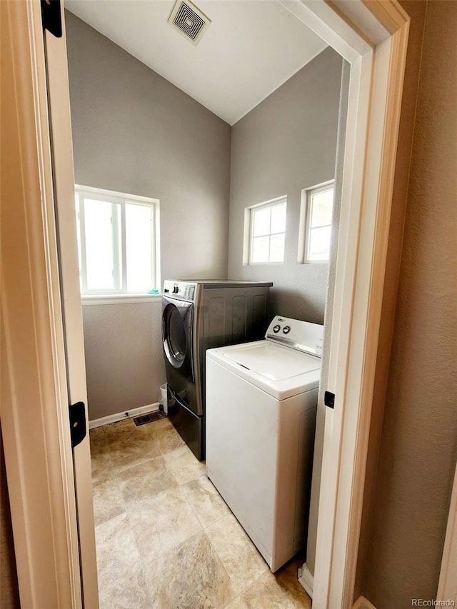 laundry area featuring washer and clothes dryer, visible vents, and laundry area