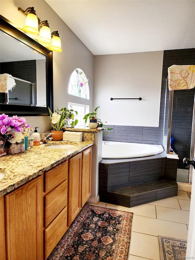 full bathroom with vanity, tile patterned flooring, and a garden tub
