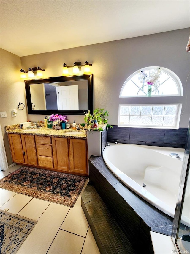 bathroom featuring a sink, a bath, and double vanity