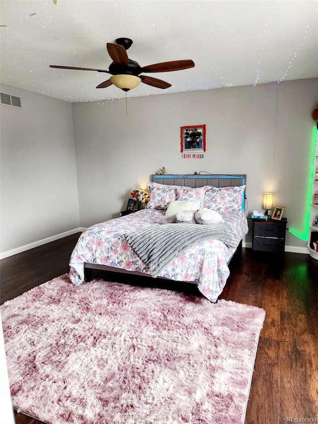 bedroom featuring wood finished floors, ceiling fan, baseboards, and visible vents