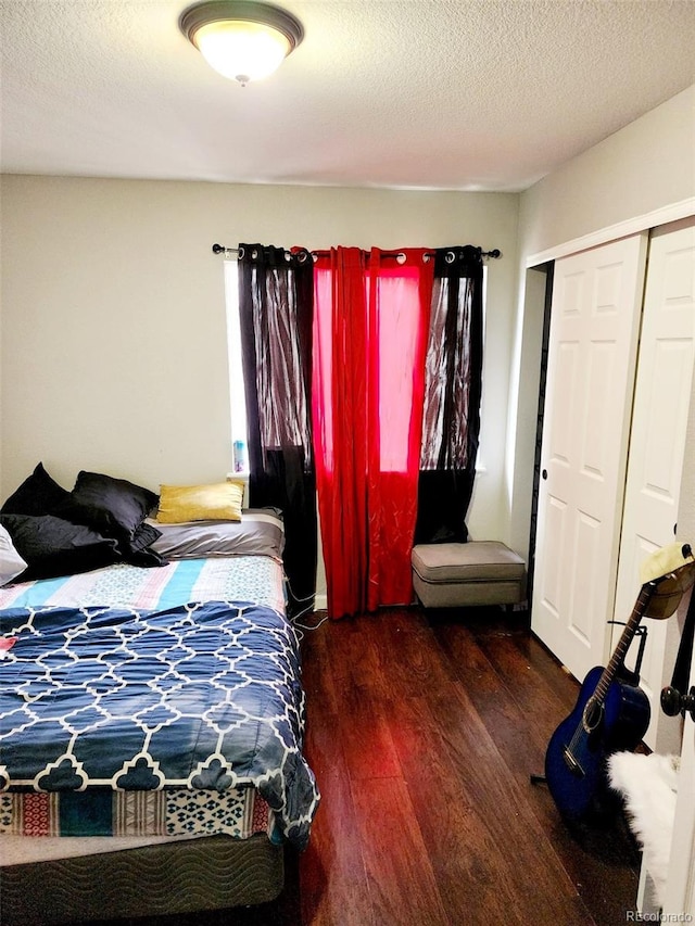 bedroom with a closet, a textured ceiling, and wood finished floors