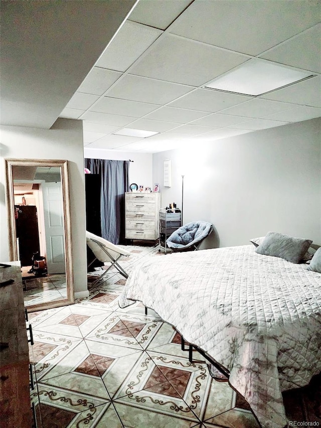 bedroom featuring tile patterned floors and a paneled ceiling