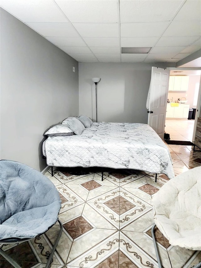 bedroom with light tile patterned floors and a paneled ceiling