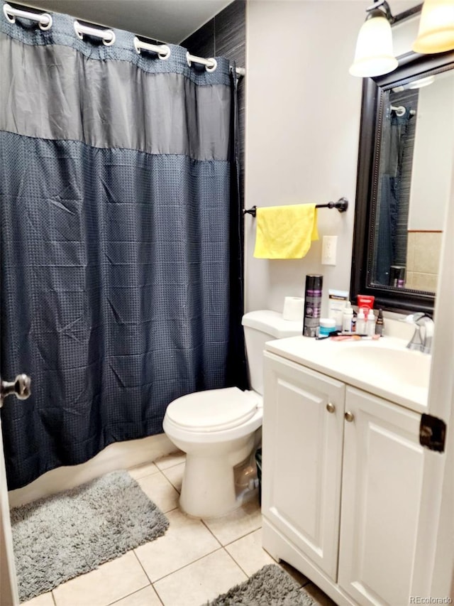bathroom with toilet, vanity, tile patterned flooring, and a shower with curtain