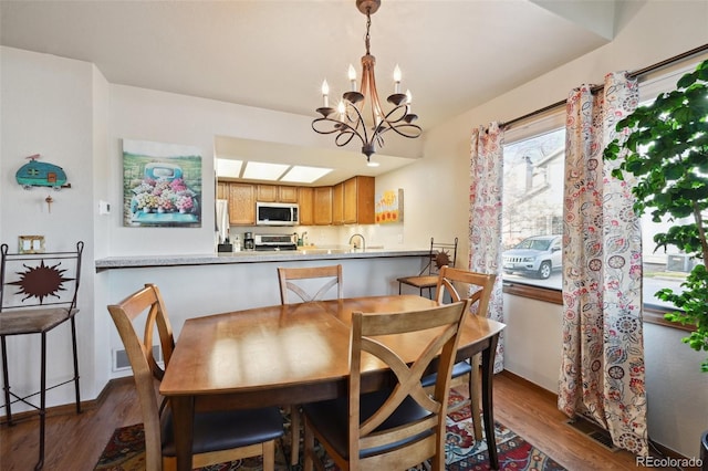 dining room featuring dark hardwood / wood-style floors, a chandelier, and sink