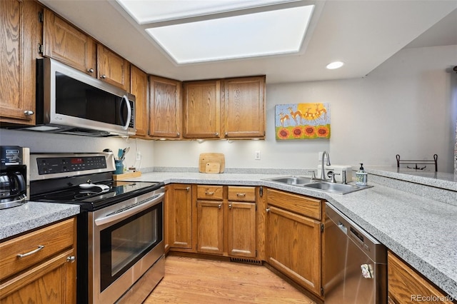 kitchen featuring sink, light wood-type flooring, and appliances with stainless steel finishes