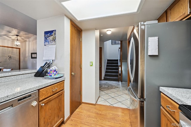 kitchen with appliances with stainless steel finishes and light hardwood / wood-style flooring