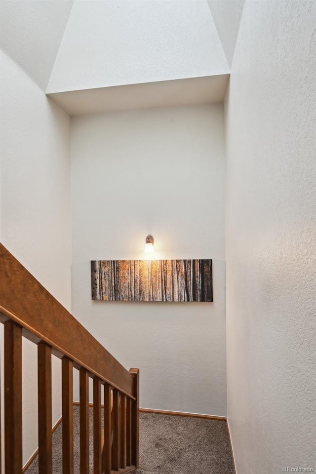 stairway with carpet flooring and vaulted ceiling