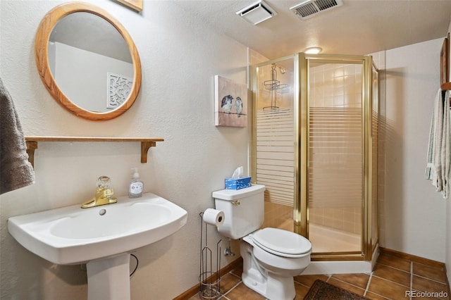 bathroom featuring tile patterned flooring, toilet, and walk in shower