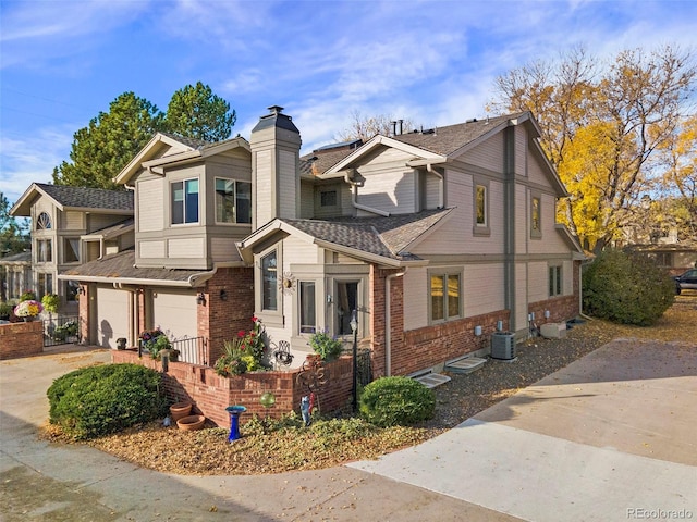 view of front of home with central AC unit and a garage