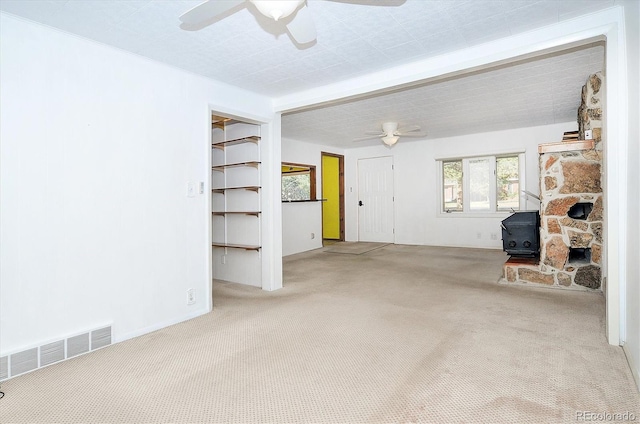 garage featuring ceiling fan and a wood stove