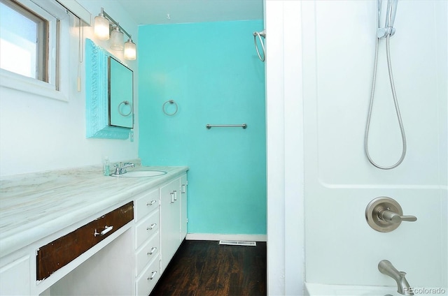 bathroom featuring hardwood / wood-style floors, walk in shower, and vanity