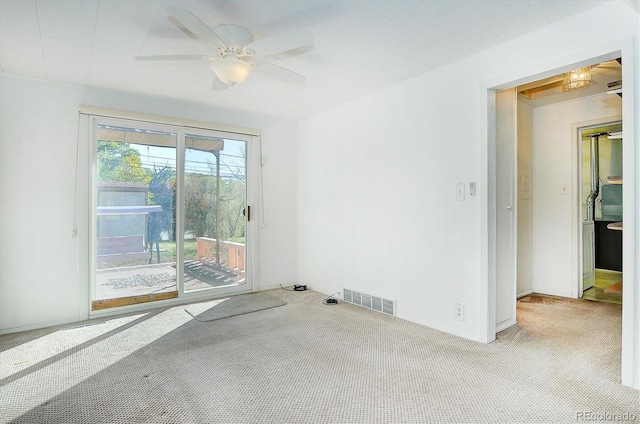 carpeted spare room with ceiling fan