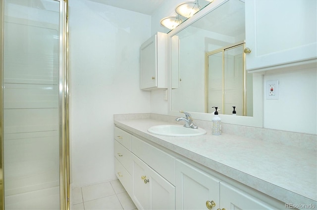 bathroom featuring tile patterned floors, a shower with shower door, and vanity