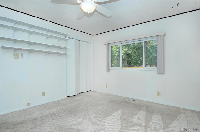 unfurnished bedroom featuring ceiling fan and light carpet