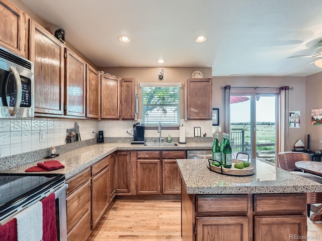 3691 Bucknell Dr, Highlands Ranch, CO 80129 - kitchen featuring appliances with stainless steel finishes, light wood-style flooring, ceiling fan, light stone countertops, and backsplash