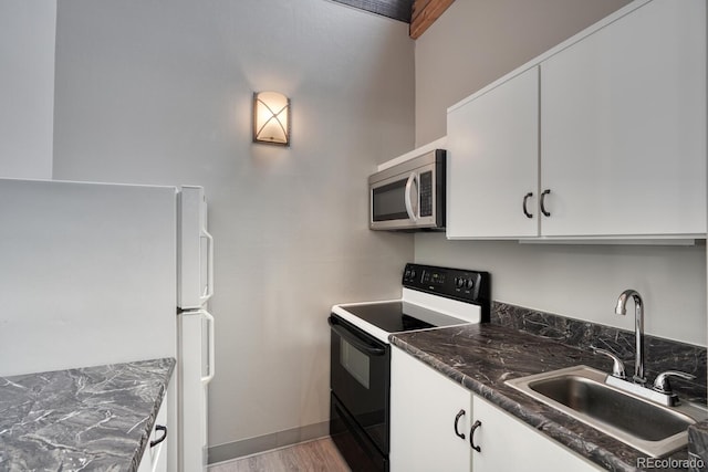 kitchen featuring sink, white cabinets, and black electric range