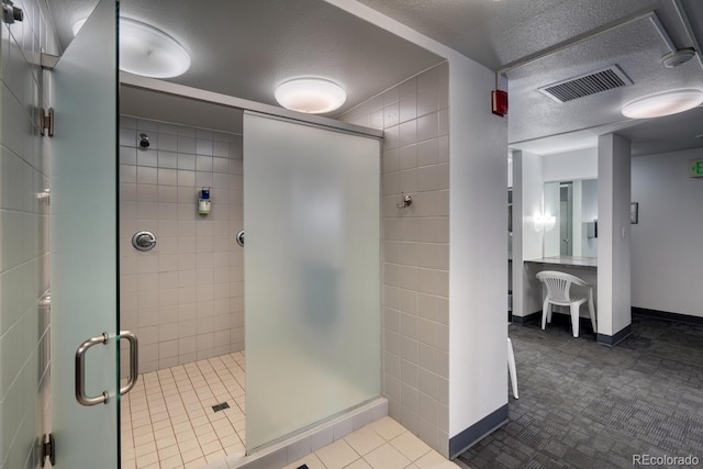 bathroom featuring tile patterned floors, a shower with door, tile walls, and a textured ceiling