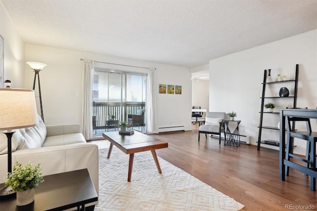 living room with hardwood / wood-style floors, a baseboard radiator, and a textured ceiling