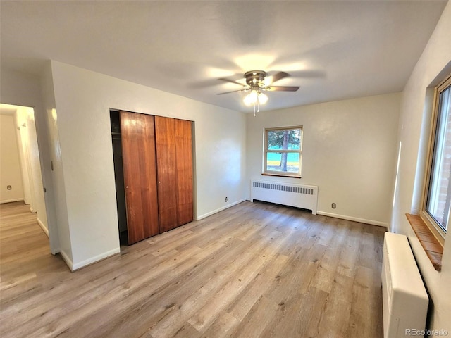 18 Columbia Dr, Julesburg, CO 80737 - unfurnished bedroom with radiator heating unit, light wood-style floors, baseboards, and a closet
