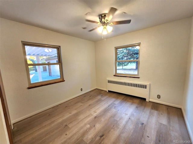 18 Columbia Dr, Julesburg, CO 80737 - spare room featuring radiator heating unit, plenty of natural light, wood finished floors, and a ceiling fan