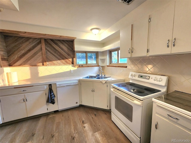 18 Columbia Dr, Julesburg, CO 80737 - kitchen with white appliances, a sink, tasteful backsplash, wood finished floors, and white cabinets