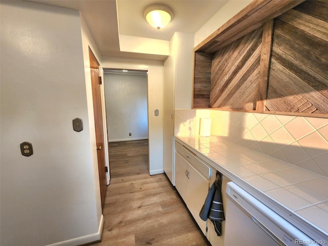 18 Columbia Dr, Julesburg, CO 80737 - bar featuring white dishwasher, tasteful backsplash, light wood-type flooring, and baseboards