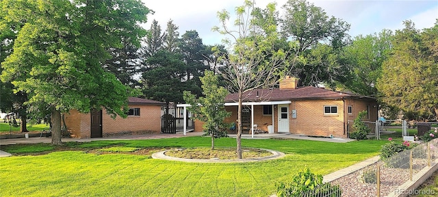 18 Columbia Dr, Julesburg, CO 80737 - rear view of house featuring brick siding, a vegetable garden, a chimney, and a gate