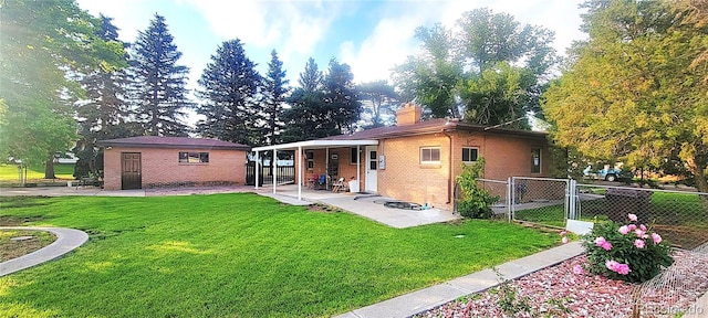 18 Columbia Dr, Julesburg, CO 80737 - rear view of property featuring brick siding, a patio, a chimney, and a gate
