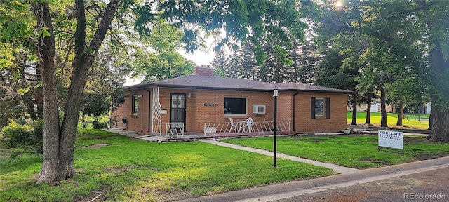 18 Columbia Dr, Julesburg, CO 80737 - single story home featuring a front lawn, brick siding, and a chimney