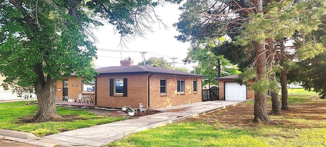 18 Columbia Dr, Julesburg, CO 80737 - view of front of home featuring an outdoor structure, a chimney, concrete driveway, brick siding, and a garage