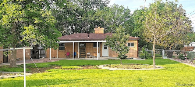 18 Columbia Dr, Julesburg, CO 80737 - back of house with a patio area, a chimney, and brick siding