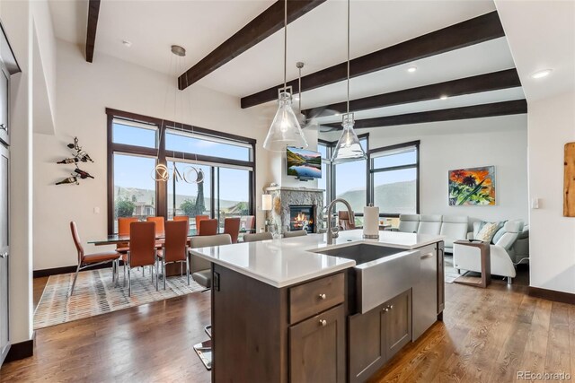 14 E Baron Way, Silverthorne, CO 80498 - kitchen featuring open floor plan, a fireplace, light countertops, a center island with sink, and beam ceiling
