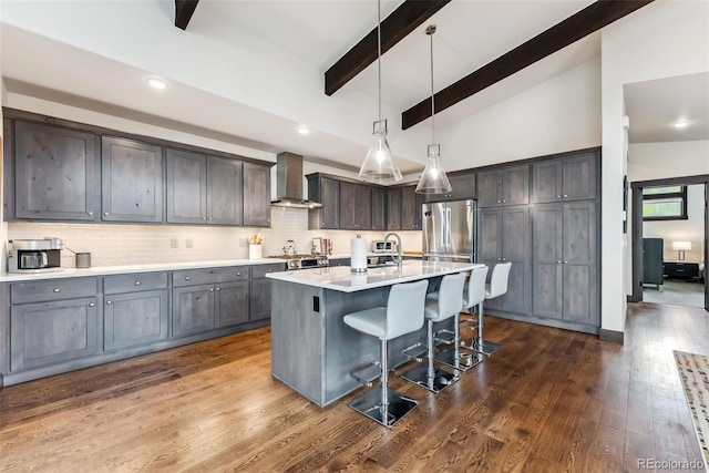 14 E Baron Way, Silverthorne, CO 80498 - kitchen with wall chimney exhaust hood, stainless steel refrigerator, a kitchen breakfast bar, dark wood-style flooring, and light countertops