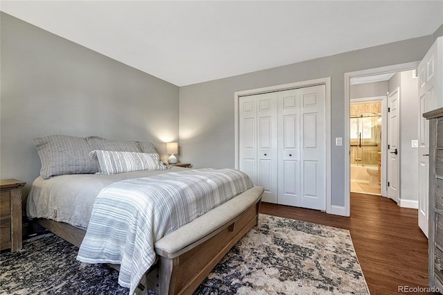 bedroom featuring baseboards, wood finished floors, and a closet