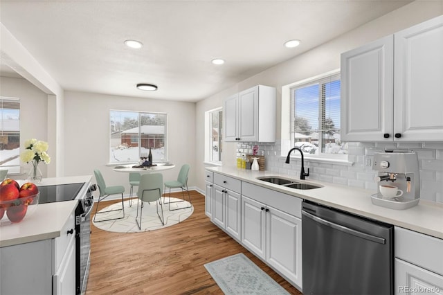 7555 E 22nd Ave, Denver, CO 80207 - kitchen with stainless steel dishwasher, a sink, decorative backsplash, plenty of natural light, and recessed lighting