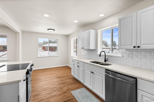 7555 E 22nd Ave, Denver, CO 80207 - kitchen featuring stainless steel dishwasher, a sink, range with electric cooktop, healthy amount of natural light, and recessed lighting