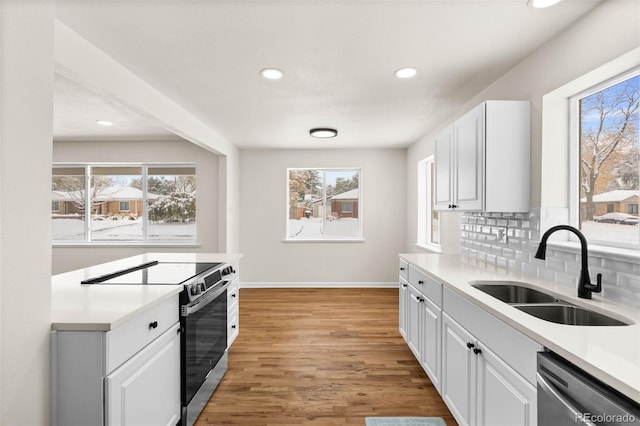 7555 E 22nd Ave, Denver, CO 80207 - kitchen featuring a sink, appliances with stainless steel finishes, plenty of natural light, baseboards, and recessed lighting