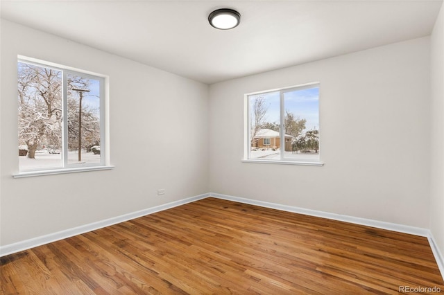 7555 E 22nd Ave, Denver, CO 80207 - empty room featuring healthy amount of natural light, baseboards, and wood finished floors