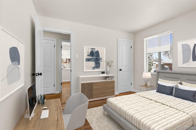 7555 E 22nd Ave, Denver, CO 80207 - bedroom featuring multiple windows, wood finished floors, and baseboards