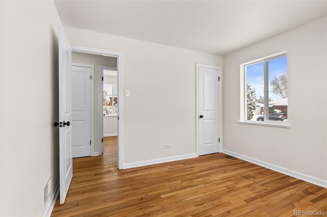 7555 E 22nd Ave, Denver, CO 80207 - unfurnished bedroom featuring light wood-type flooring and baseboards