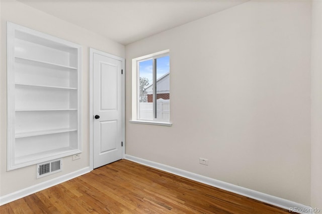 7555 E 22nd Ave, Denver, CO 80207 - unfurnished bedroom with baseboards and wood finished floors
