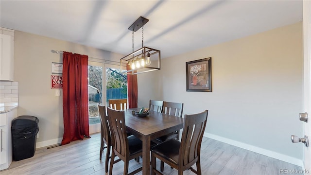 dining room featuring a notable chandelier and light hardwood / wood-style floors