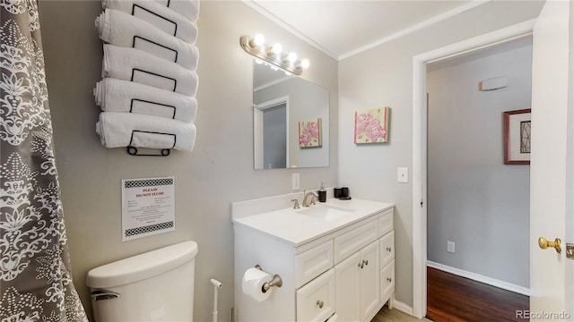 bathroom with vanity, toilet, wood-type flooring, and ornamental molding