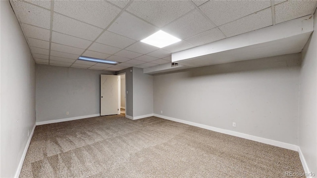 spare room with carpet flooring and a drop ceiling